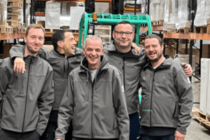 Happy workers in a warehouse celebrating a work anniversary.